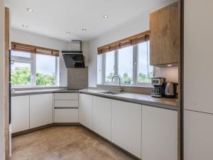 eine leere Küche mit weißen Schränken und Fenstern in der Unterkunft Avon Lock Cottage - Uk34125 in Tewkesbury