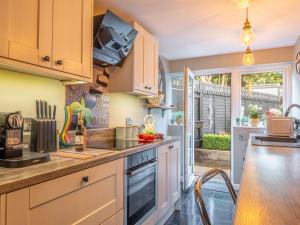 une cuisine avec des armoires blanches et un comptoir dans l'établissement Riverside Cottage, à Reedham