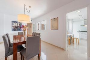 ein Esszimmer und ein Wohnzimmer mit Tisch und Stühlen in der Unterkunft Sea Two in Port de Pollença