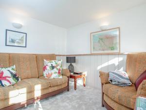 a living room with a couch and a table at Welcome Cottage in Woolfardisworthy