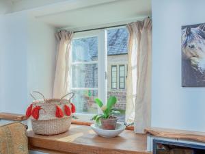 a room with a window with a plant on a table at Welcome Cottage in Woolfardisworthy
