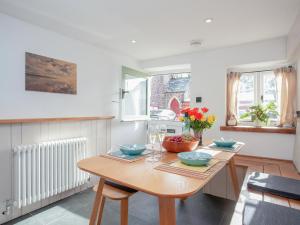 a kitchen with a wooden table with flowers on it at Welcome Cottage in Woolfardisworthy