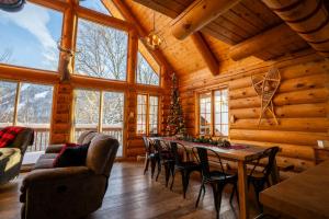 een eetkamer met een tafel in een blokhut bij L'Antaya - SPA Mountain in Saint-Philémon