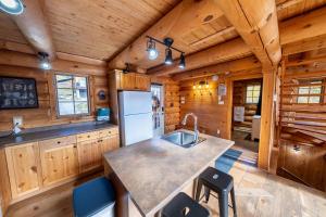 een keuken met een spoelbak en een koelkast bij L'Antaya - SPA Mountain in Saint-Philémon