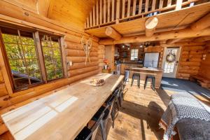 een eetkamer met een houten tafel in een blokhut bij L'Antaya - SPA Mountain in Saint-Philémon