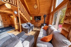 een woonkamer met banken en stoelen in een blokhut bij L'Antaya - SPA Mountain in Saint-Philémon +21 foto's