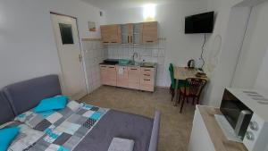 a small room with a kitchen and a bed and a table at Magma Grzybowo in Grzybowo
