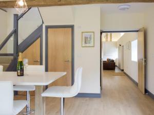 a dining room with a white table and white chairs at The Garden Room At Eudon George in Shipton