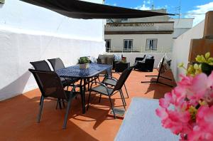 a patio with a table and chairs on a balcony at Casa Ibaía, típica e acolhedora no centro de Olhão in Olhão