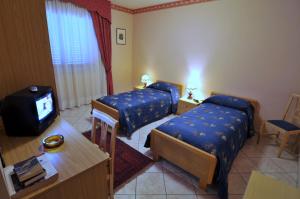 pokój hotelowy z 2 łóżkami i telewizorem w obiekcie Hotel Ristorante Thomas w mieście Torregrotta