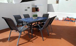 a table with black chairs and a blue table with a potted plant at Casa Ibaía, típica e acolhedora no centro de Olhão in Olhão +20 photos