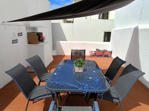a table with chairs and a blue table cloth on it at Casa Ibaía, típica e acolhedora no centro de Olhão in Olhão