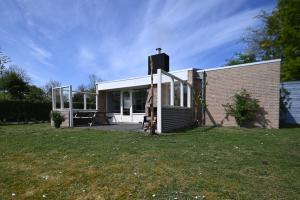 a small house with a lawn in front of it at Villa Mer - Terra Nova, detached bungalow with XXL garden, near the beach in Cadzand