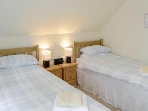 zwei nebeneinander stehende Betten in einem Schlafzimmer in der Unterkunft Rowan Cottage in Glenrossal