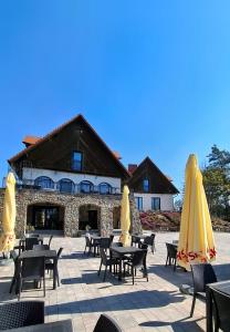 un patio con mesas, sillas y sombrillas en Wrzosowe Love, en Raciąż