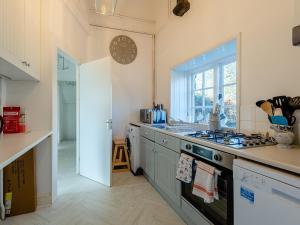 a kitchen with a stove and a clock on the wall at The Barn in Hunstanton
