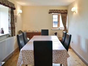 a dining room with a table and chairs at Two Bridge Cottage in Winsham
