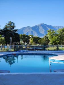 an empty swimming pool with mountains in the background at Sayacuna Huasi Cabañas in Tafí del Valle