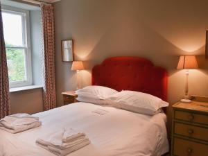 1 dormitorio con 1 cama con cabecero rojo y almohadas en Treburthick House, en Charlestown 16 fotos más