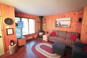 a living room with a couch and a tv at Escapade parfaite - SPA Condo in Saint-Philémon