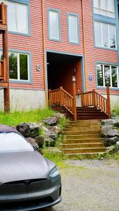 a house with a wooden porch and stairs in front at Escapade parfaite - SPA Condo in Saint-Philémon