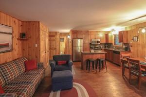 a living room with a couch and a kitchen at Escapade parfaite - SPA Condo in Saint-Philémon +17 photos