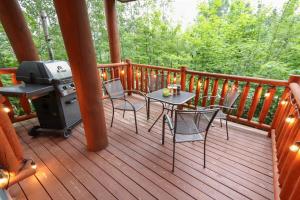 a grill on a deck with a table and chairs at Escapade parfaite - SPA Condo in Saint-Philémon