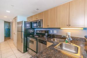 マートルビーチにあるOceans One 1806のステンレス製の冷蔵庫とシンクを備えたキッチン