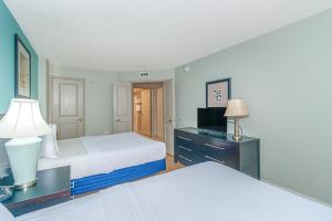 マートルビーチにあるOceans One 1806のベッド2台とテレビ付きの机がある寝室 +41枚の写真