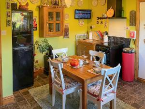 a kitchen with a wooden table and chairs and a refrigerator at Mystified Bungalow in West Burton