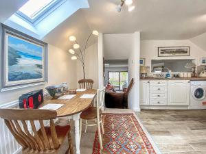 une salle à manger avec une table et des chaises et une cuisine dans l'établissement Caroline Cottage, à Warminster