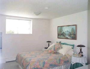 een slaapkamer met een bed en een raam bij Island View B&B in Nanaimo