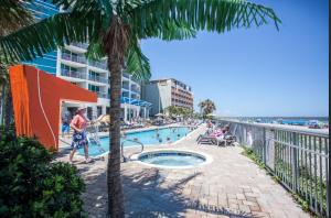マートルビーチにあるOceans One 1806のヤシの木があるビーチのそばのスイミングプール