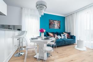 a living room with a blue couch and a table at Apartament AQUAMARIN Sarbinove Prestige by BALTIC CLUB in Sarbinowo