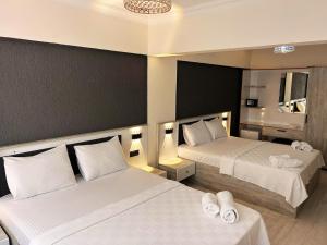 a hotel room with two beds with white sheets at Ephesus Nobel Otel in Selcuk