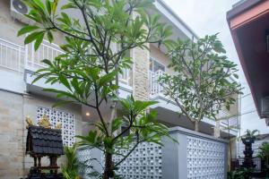 two trees in front of a building at Full Moon Home Stay in Canggu