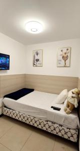 a bedroom with a bed with a teddy bear on it at Ecuabook Torre Sol Family Apartment 901 in Guayaquil