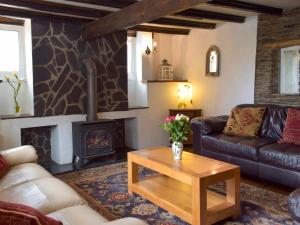 a living room with a couch and a wood stove at The Carthouse - Uk13184 in Cwm-Morgan