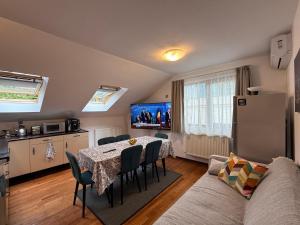 a kitchen and dining room with a table and a couch at Emun Grigo Lofthouse in Cluj-Napoca