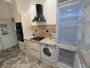 a kitchen with a washer and dryer in a kitchen at VENI VEDI VICHY climatisé, 50m2 coeur de ville in Vichy