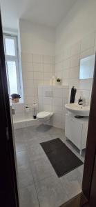 a white bathroom with a toilet and a sink at 3BR - Bremerhaven Apartment in Bremerhaven +6 photos