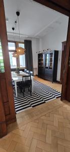a living room with a table and chairs on a rug at 3BR - Bremerhaven Apartment in Bremerhaven