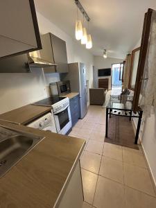 Una cocina con un fregadero y una mesa dentro. en Studio 5 minutes from RER A, en Nanterre