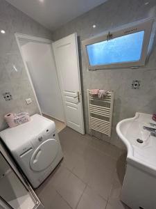Un baño con un inodoro blanco y un lavabo. en Studio 5 minutes from RER A, en Nanterre