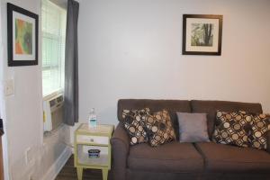 a living room with a brown couch and a table at HISTORIC HILL APT2 (Downstairs) in Tuskegee