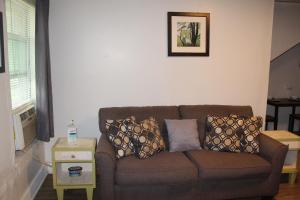 a living room with a brown couch with pillows on it at HISTORIC HILL APT2 (Downstairs) in Tuskegee