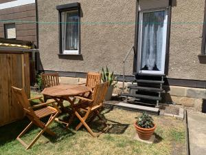 a wooden table and chairs in front of a house at Ferienwohnung Wolfi in Gotha