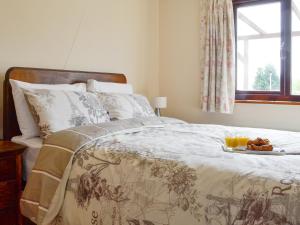 a bedroom with a bed with a tray of food on it at Three Views Bungalow in Talgarth +10 photos