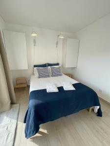 a bedroom with a large blue bed with two pillows at That Place For U - Blue House in Costa da Caparica