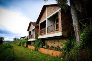 a brick house with a balcony on the side of it at Chalés da Gameleira in Areia